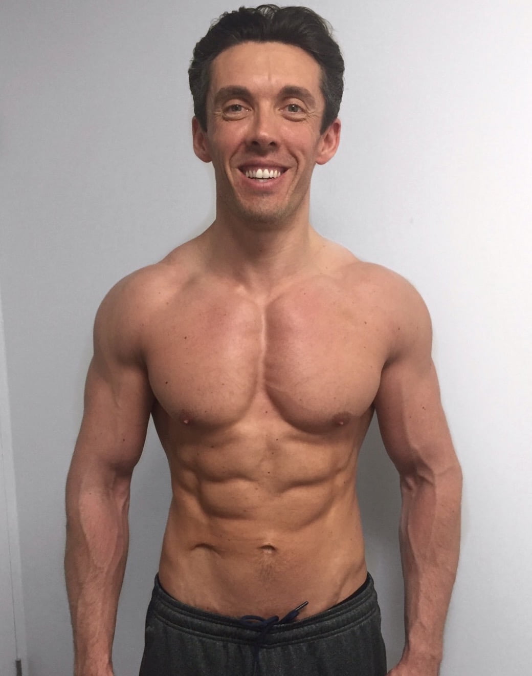 Male transformation after photo with defined chest and abs at Roar Fitness