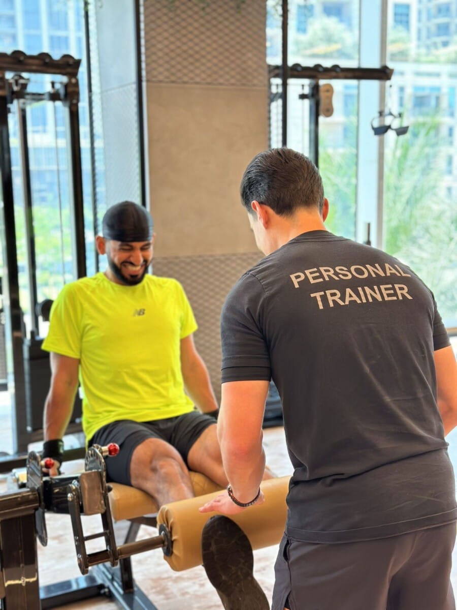 Personal trainer assisting client at Roar Fitness Dubai training studio