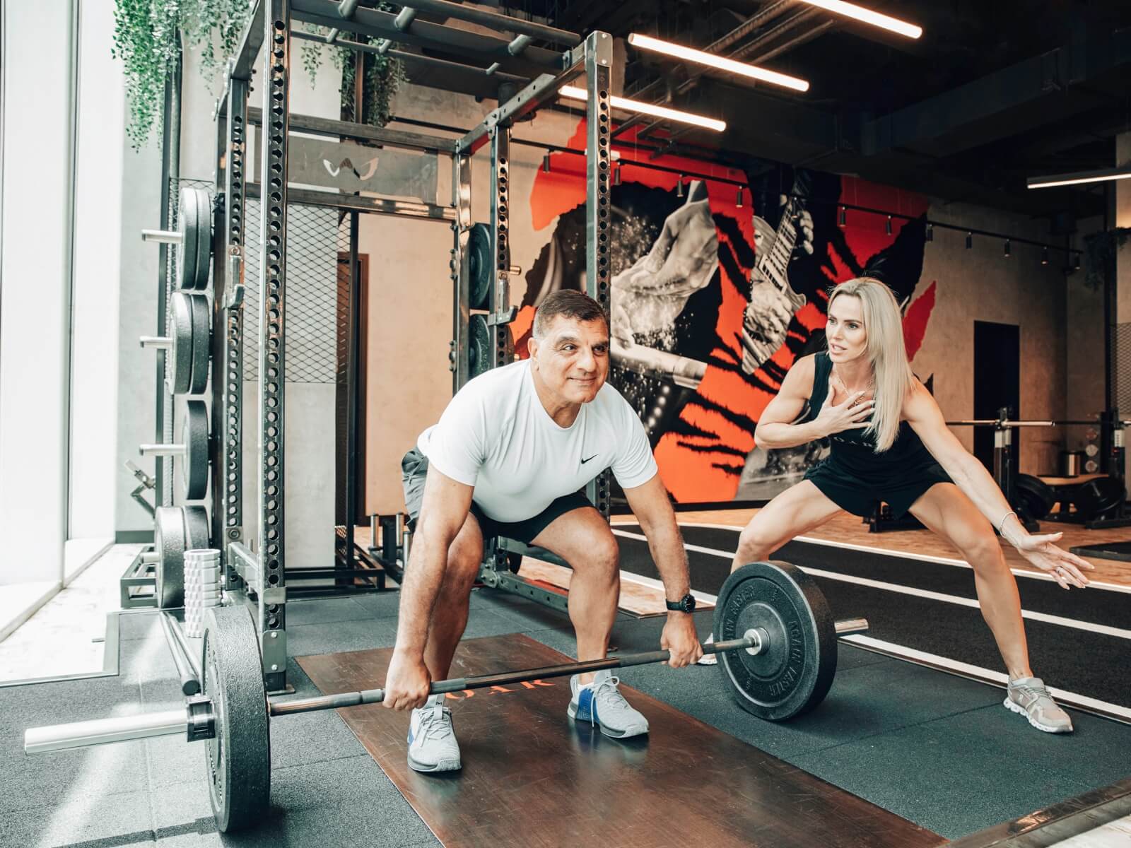 Coach guiding a client through a deadlift during a personal training session in Dubai