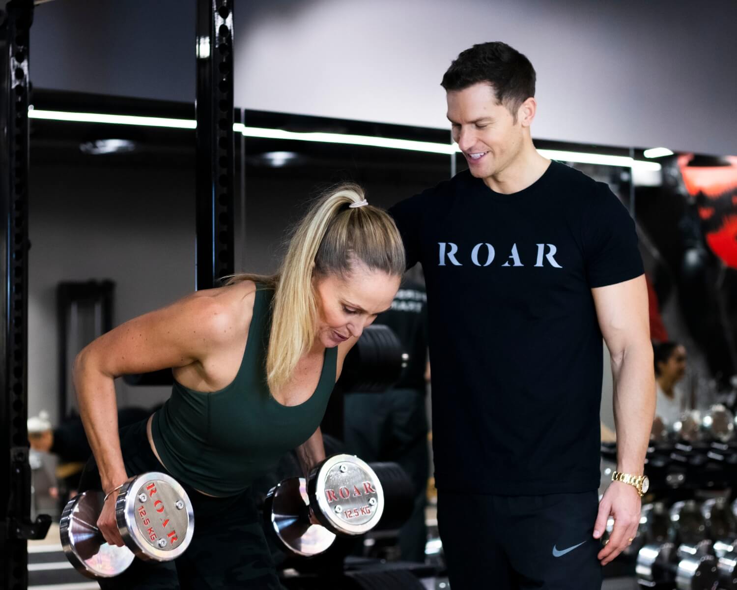 Rich Phillipps, Roar Fitness co-founder, coaching a client through a dumbbell row