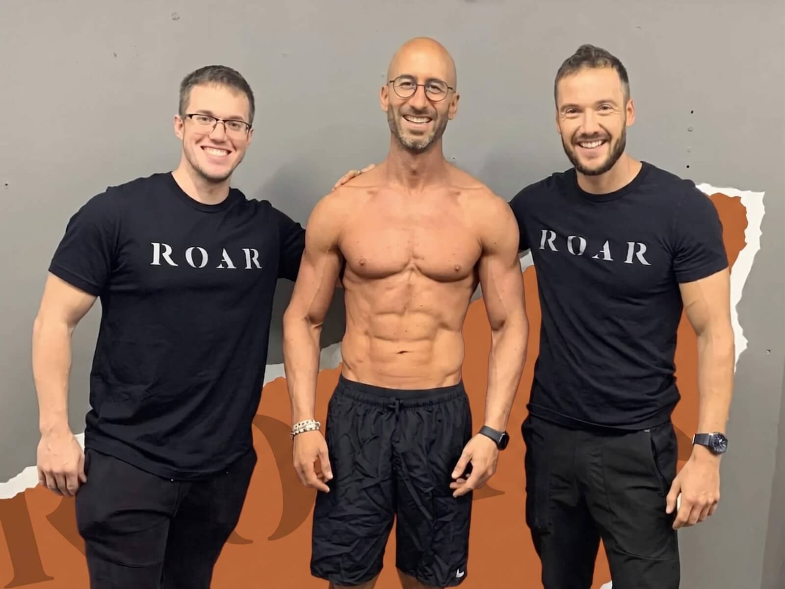 Two Roar Fitness personal trainers celebrating with a lean, muscular client after completing his body transformation programme