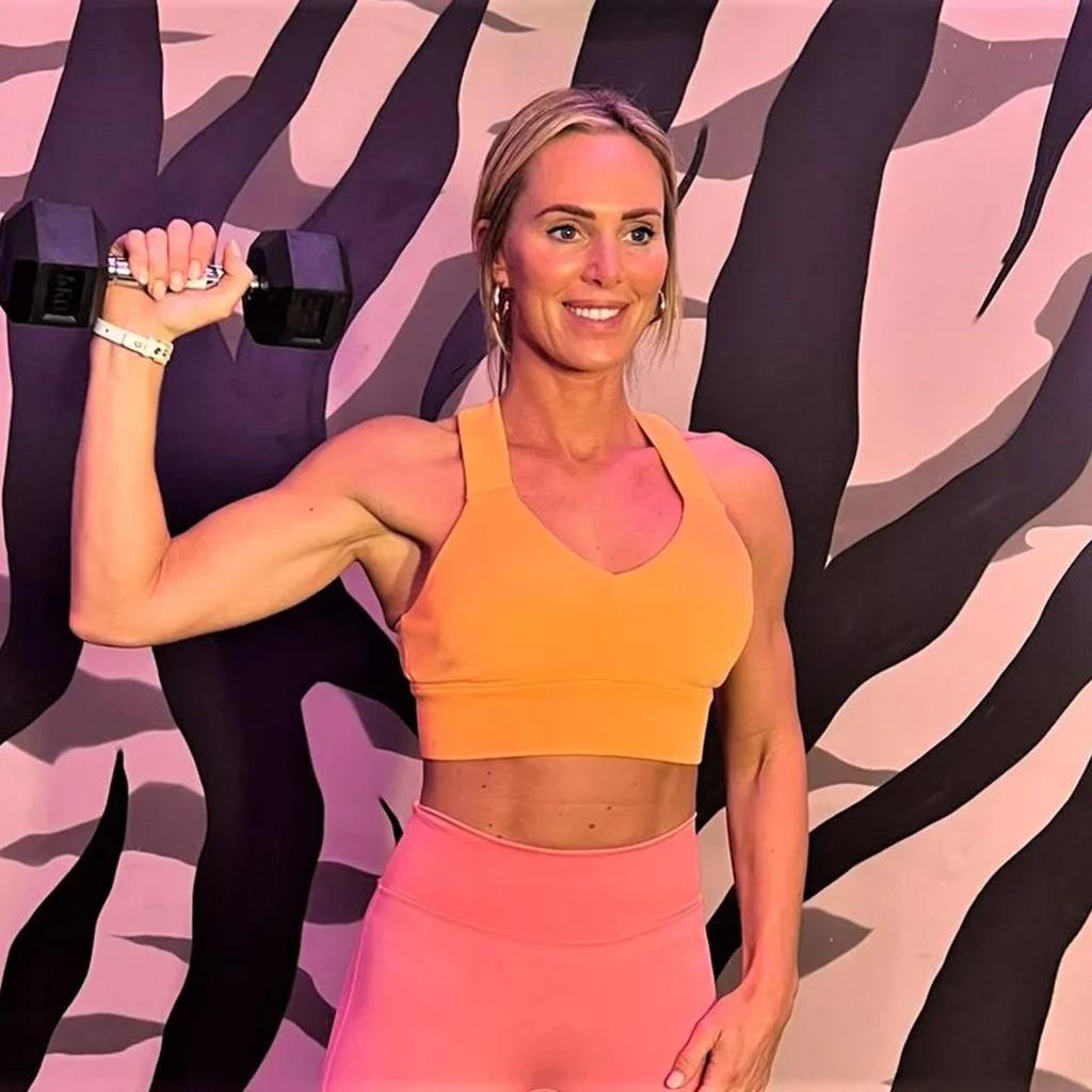 Sarah Lindsay doing a dumbbell shoulder press for Women's Fitness